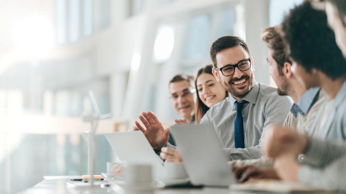 Young happy entrepreneur talking to his colleagues during a business meeting in a board room.