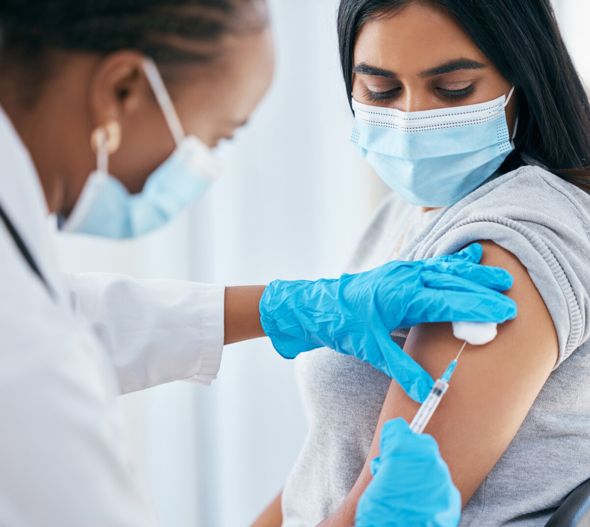 Healthcare, covid vaccine injection and woman with doctor with surgical gloves in hospital or clinic. Healthcare, medical insurance and vaccination innovation, global infection safety in medicine.